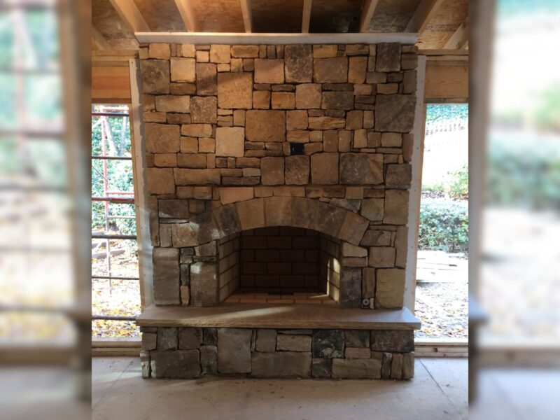Floor-to-ceiling custom dry-stack stone fireplace built by Atlanta Waterscapes in a Sandy Springs home addition
