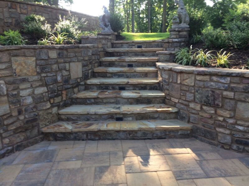Tiered natural stone retaining walls and stone steps in a Buckhead backyard transformation by Atlanta Waterscapes